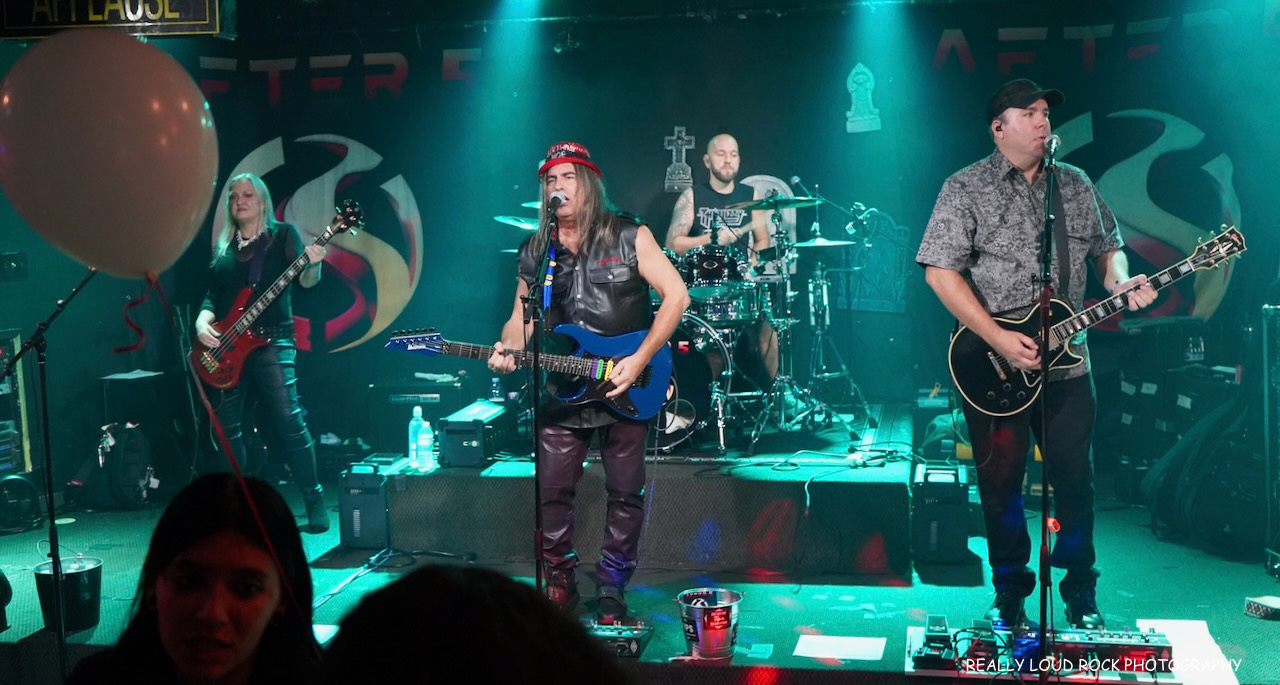After 5's full line-up on stage under teal light