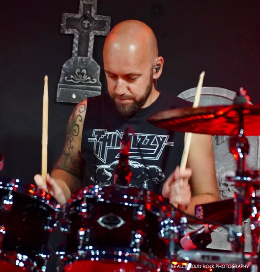 After 5's drummer behind the kit, sticks raised