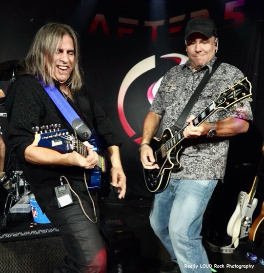 Two After 5 guitarists in front of the band's backdrop