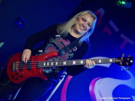 After 5's bass player in front of the band's backdrop